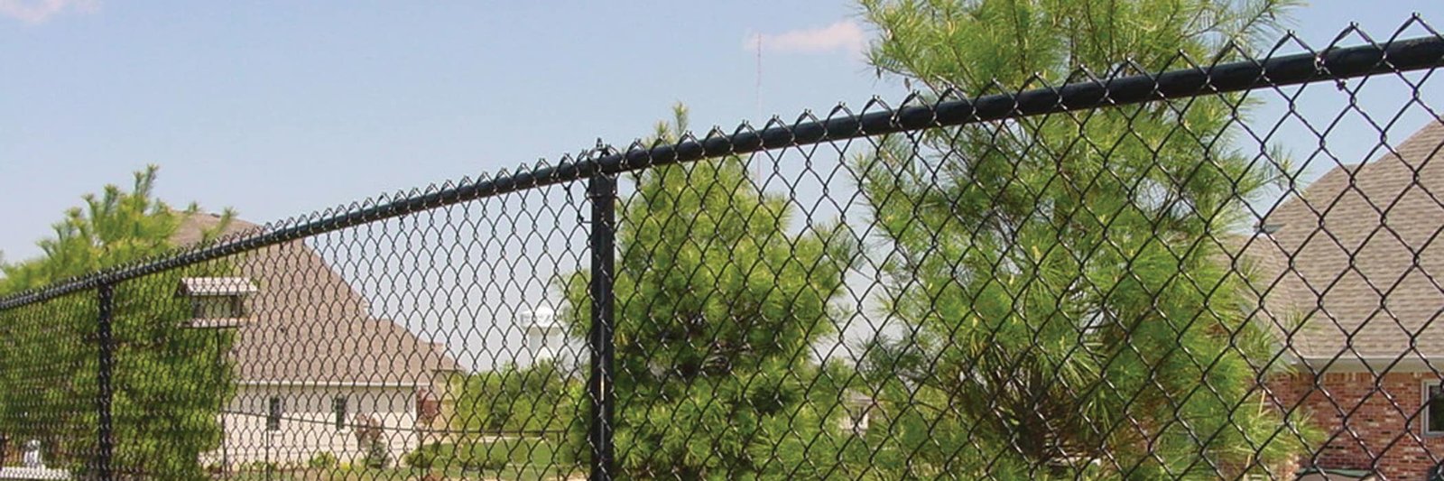 Black vinyl-coated chain link fence installed along a residential yard boundary