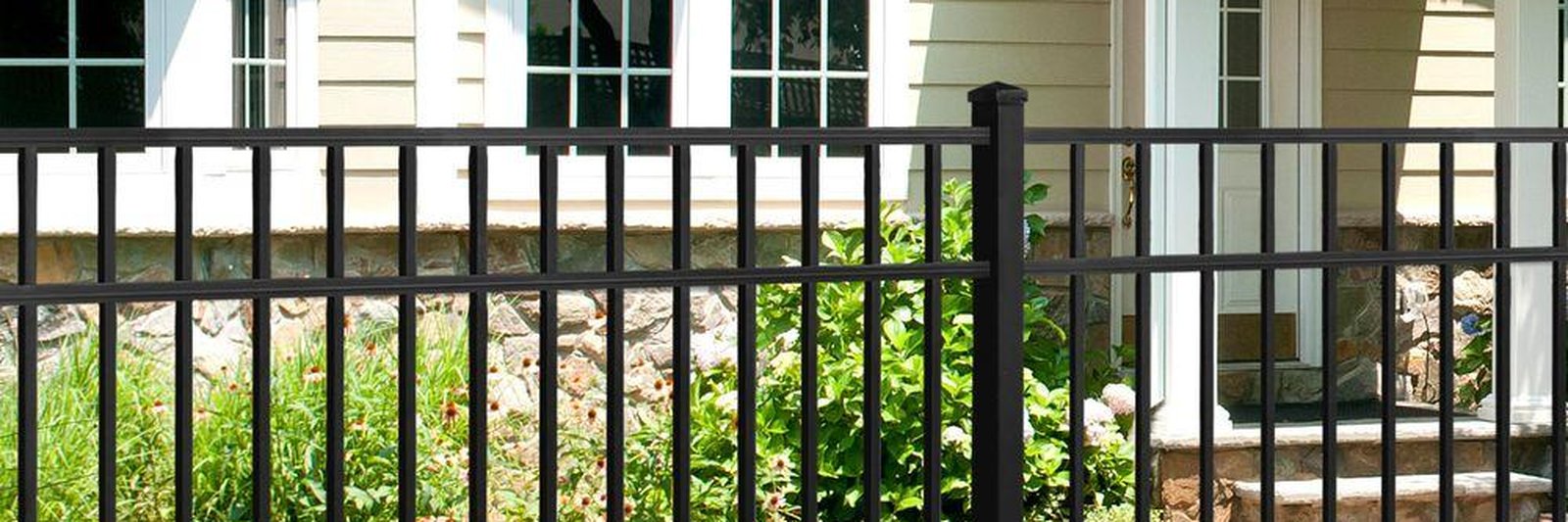 Black powder-coated ornamental steel fence with spear-top pickets installed on a residential boundary